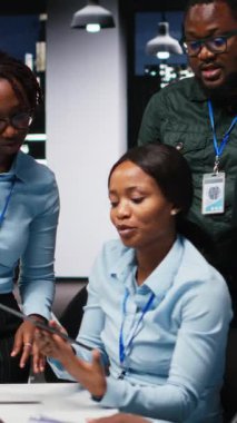 Bir ofis toplantısında veri finansmanını inceleyen dikey video şirketi çalışanları, şirket faaliyeti için saatler sonra yeni bir büyüme stratejisi geliştirmeden önce analiz projeksiyonuna danışmaktadırlar.