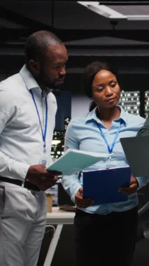 Dikey Video Black şirket personeli ofiste rapor yazma üzerinde birlikte çalışarak yeni bir geliştirme stratejisi oluşturmaya çalışıyor. Verimliliği ve ilerlemeyi arttırmak için görüşler gözden geçiriliyor