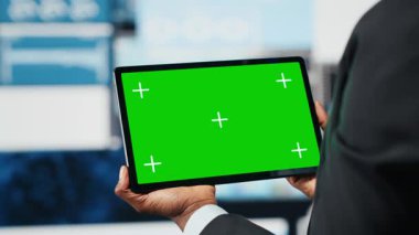 Karar vermeden önce şirket ölçümlerini karşılaştırmak için takım lideri tarafından kullanılan yeşil ekran tableti. Mokup aygıtı kullanarak anahtar performans göstergelerini profesyonelce analiz et, kapat