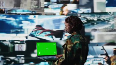 Hava savunma komutanı, yaklaşan balistik füzeleri tespit etmek için yeşil ekran model dizüstü bilgisayarı kullanıyor. Ordu askeri, kroma anahtar izole ekran defteri ve kamera A kullanarak düşman roketlerini tarıyor.