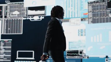 İş uzmanı gurur duyuyor, performans gösterge tablosunu inceledikten sonra göğüs pompalıyor ve kazanımları görüyor. Yönetici, olumlu yıllık rapor verilerinin ardından kutlama yapıyor, zafer jestleri yapıyor, kamera B