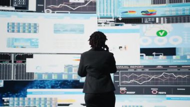 İş uzmanları telefon üzerinden strateji planlaması yapıyor, performans ölçümlerini gözden geçiriyorlar. Yönetici iş ortağıyla konuşmak için cep telefonunu kullanıyor, yıllık rapor verileri değerlendiriliyor, kamera A