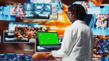 Tıbbi taramaları incelemek için bilim adamı tarafından kullanılan izole ekran bilgisayarı. Dijital sağlık panelinin önündeki kadın insan anatomisini krom anahtar not cihazı ile analiz ediyor, kamera A