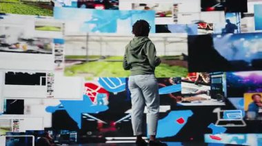 İçerik yaratıcısı mikrofonu kullanarak nüfuz eden yaşam tarzı ve sosyal ağ deneyimleri hakkında konuşuyor. Afro-Amerikalı kadın, seyircilerin önünde konferans sunumu yapıyor, videolar gösteriyor, kamera A