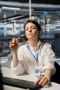 Sunucu odasında veri yedekleme çözümlerini uygulamak ve yönetmek için bilgisayar kullanıyor. Veri Merkezi Mühendisi, teknik sorunları tespit ederek ve çözerek, verimli bir iyileşme sağlayarak