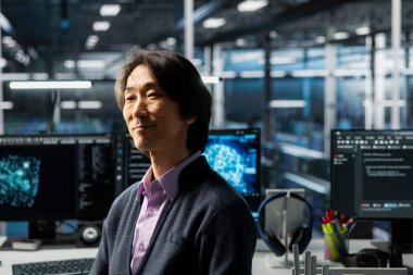 Veri merkezindeki kıdemli programcı, yapay zeka uygulamalarını destekleyen veritabanları üzerinde çalışıyor. Sunucu merkezinde mutlu Asyalı bilişim uzmanı yapay zeka algoritmaları üzerinde deneyler yapıyor.