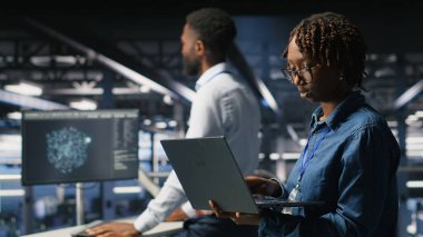 Sunucu çiftliğindeki veri bilimci sinirsel ağ kodunu ve LLM görselleştirme panelini inceliyor. Bilgi işlem merkezi endüstriyel platformunda yürüyen bilişim uzmanı, AI sistem performansını izliyor