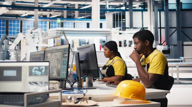 Afrikalı Amerikalı teknisyen, gelişmiş izleme ve üretim araçları kullanarak PC istasyonundaki yenilenebilir enerji ölçümlerini değerlendiriyor. Mühendis güneş enerjisinin hassasiyetini geliştiriyor. Kamera B.