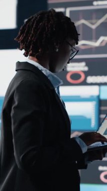 Dikey video yöneticisi iş piyasası grafiklerini değerlendiriyor dizüstü bilgisayar yazılımı kullanıyor, beyin fırtınası yapıyor. İş kadını iş görüşleri için not defteri programında mali raporları ve veri grafiklerini analiz ediyor