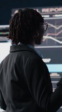 İşletme koçunun dikey videosu. İzleyiciler önünde nota sunumuna ev sahipliği yapıyor. Kongrede yatırım stratejileri öğretiyor. Açık konuşma uzmanı öngörü grafiklerini gösteriyorName