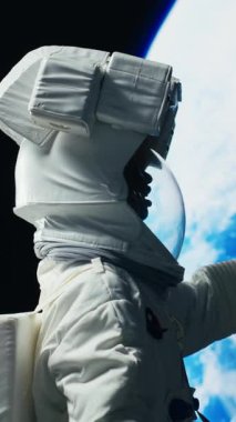 Dikey video Heyecanlı astronot gezegen gezisini bitirdikten sonra Dünya 'ya inmeye hazırlanıyor. Yüksek teknoloji elbiseli neşeli Afro-Afrikalı Amerikalı kozmonot uzay gemisiyle derin uzay görevini tamamlıyor.