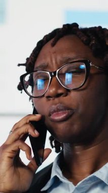 Dikey videolu kadın hissedarlarla telefon görüşmesi yapıyor, iş piyasası grafikleri hakkında konuşuyor, beyin fırtınası yapıyor. Takım lideri, ortaklarla mali raporlar ve kamera B hakkında konuşuyor.