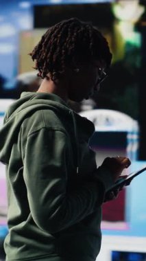 Dikey video Mutlu genç kadın video yayın hizmetlerinin içeriğinden memnun, tablet kullanarak boş zamanların tadını çıkarıyor. Gülümseyen genç cihaz B 'de VOD yayınlarını eğlendirmekten memnun.