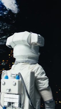 Dikey video Heyecanlı astronot gezegen gezisini bitirdikten sonra Dünya 'ya inmeye hazırlanıyor. Yüksek teknoloji elbiseli neşeli Afro-Afrikalı Amerikalı kozmonot uzay gemisiyle derin uzay görevini tamamlıyor.