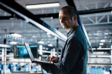 Neşeli sunucu tarım işçisi karmaşık yapay zeka hesaplamalarını hızlandırmak için özel donanım kullanır. Yapay zeka eğitimini etkinleştirmek için veri merkezinde bilgisayar kaynakları ve depolama sağlayan gülümseyen mühendisin portresi