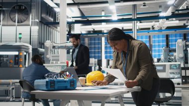 Güneş enerjisi üretimi üzerinde kalite kontrolü yapan kadın endüstriyel uzman, altyapı geliştirme ile daha ucuz alternatif enerji sergiliyor. Endüstri mühendisliği. Kamera A.