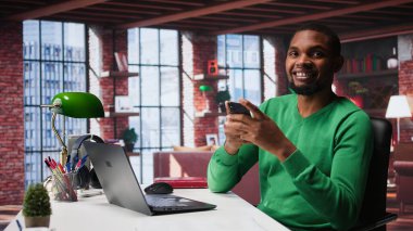 Cep telefonundaki sosyal medya uygulamalarını kontrol etmek için işten izin alan bir adam evde dinlenirken eğleniyor. Tavan arasında sosyal ağ uygulamasını telefonla kullanmak için duraksayan genç bir adam. Kamera B.