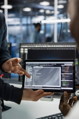 Bilgi Merkezi 'nin veri merkezini kapatın. Bilgi işlem personeli tablet üzerinde kodlanıyor, sunucular yerleştiriliyor. Sunucu odasında aygıt kullanan, beyin fırtınası yapan, büyük ölçekli bilişim altyapısını yöneten programcılar.