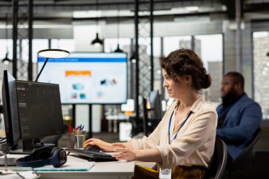 Modern bir ofiste profesyonel bir ofis çalışanı, hisse senedi eğilimlerini ve şamdan çizelgelerini bir monitörde izleyerek, ticaret ve gelir hedeflerini optimize etmek ve elde etmek için tahmin ve finans stratejisini kullanarak.