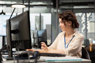 Yönetici bir bilgisayarda mali veri bilgileriyle ilgileniyor, yenilikçi iş çözümleri geliştiriyor ve proje hedeflerini şirket hedeflerine göre hizalıyor. Şirket ortamı.