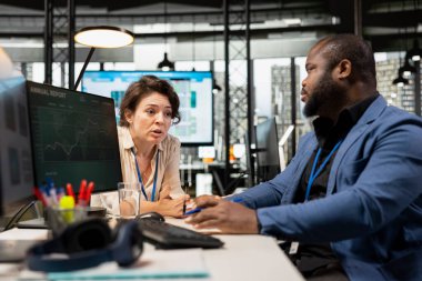 Rapor oluşturmak, yenilikçiliği teşvik etmek ve şirket performansını artırmak için iş stratejisi ve analizi uygulamak amacıyla aylık veri grafiklerini gözden geçiren yönetici ve asistan. İş birliği.