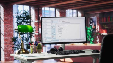 Lüks bir dairede yazılım geliştirme ve kodlama için kullanılan boş masaüstü monitörü. Modern çalışma istasyonu veya şık bir stüdyoda teknolojik performansı ve büyük veri sistemlerini destekler.