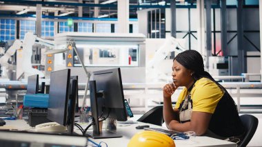 Afrika kökenli Amerikalı işçi programları otomasyon ayarları güneş tesisinde, verimlilik ve sürdürülebilirlik üzerine odaklandı. Kadın mühendis, güç çıkışının iyileştirilmesi için yapılandırmaları yönetir. Kamera B.