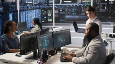 Happy Veri Merkezi Yöneticisi bilgisayarda sinirsel ağlar geliştiren bir mühendis için olumlu geri bildirim sağlıyor. Sunucu odasında, kamera A 'da yapay zeka uygulayan çalışanlardan memnun olan neşeli bir yönetici.