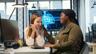 Çalışan, işteki üzgün arkadaşına yardım ediyor, iş arkadaşını rahatlatıyor, elini omzuna koyuyor. Üzgün genç kız masadaki nazik meslektaşıyla konuşuyor, duygusal destek alıyor, kamera A