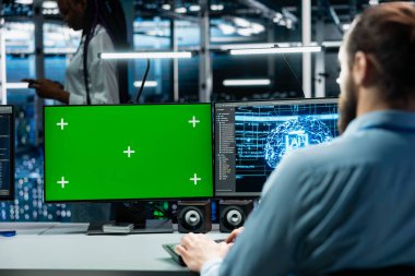 Bilgi işlem uzmanı, donanım destekli veri madenciliğiyle sunucu merkezinde yeşil ekran PC kullanıyor. Bilgisayar bilimcisi veri merkezindeki krom anahtar bilgisayarı kullanarak cihazları kullanarak platformların bakımını yapıyor.