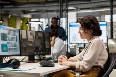 İş kadını, web sohbet etkinliğine bir hissedarla katılarak, bir brifing için performans ölçümleri hakkındaki görüşlerini paylaşıyor. İş ortakları arasında ofiste video konferansı.