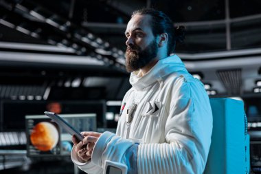 Yörünge istasyonundaki kozmonot tabletteki Mars veri analiz arayüzüne bakıyor. Yörünge istasyonunda çalışan bir adam galaksi görselleştirmesine bakıyor, Mars 'ın yüzeyini araştırıyor.