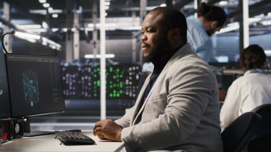 Bilgisayar masasında uzun süre oturduktan sonra yorgun sunucu çiftliği çalışanı geriliyor. Veri merkezindeki yorgun adam kaslarını gevşetiyor, uzun donanım sorun çözme seansından dolayı stresli, kamera A