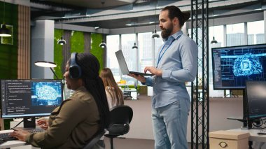 Yazılım uygulamaları geliştiren, Yapay Zeka 'yı entegre eden bir grup programcı operasyonlarda otomasyon uyguluyor. İş yerindeki geliştiriciler, sorunları çözmek için hata ayıklama uygulamaları, kamera A