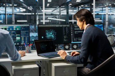 Veri Merkezi yazılım geliştiricisi AI model parametrelerini doğruluğu artırmak için ayarlıyor. Sunucu odası bilişim uzmanı yapay zeka donanım bileşenleri için bakım yaptı