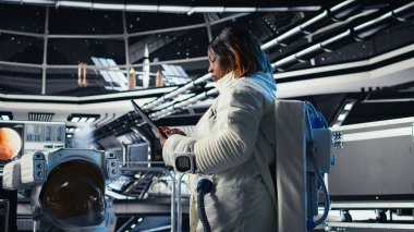 Yüksek teknolojili uzay aracının içindeki astronot rutin görev kontrolü sırasında Kırmızı Gezegen Özet Analizlerini kontrol ediyor. Mars verilerini gösteren monitörün yanında duran aygıtı kullanarak Yörünge İstasyonu Kozmonotu