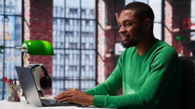 Bilgisayarda hesap tablolarını tamamlayan Afrikalı Amerikalı erkek tele-işçi hücrelere sayısal verileri giriyor ve toplamları hesaplıyor. Yazılım işlevlerini kullanan bir adam. Kamera A.