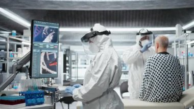 Karantinadaki doktor bulaşıcı bir hasta üzerinde klinik çalışma yapıyor, aşı tepkilerini test ediyor ve salgın hastalıklar için tedaviler geliştirmek üzere monitördeki DNA moleküllerini izliyor. Kamera A.