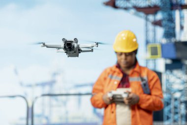 Sondaj uzmanları tarafından kullanılan insansız hava aracının güvenli mesafeden insanlara sağlık riski oluşturan bölgelere erişimi kapatın. Afrika kökenli Amerikan denizaşırı platform çalışanı hava araştırmaları için İHA kullanıyor.