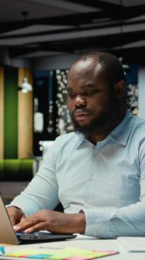 Dikey Video Dehası siyah erkek işçi saatler sonra yeni ve yenilikçi bir fikirle o anın kıvılcımını yakarak büyük bir buluş yapıyor. Parlak bir yaklaşımla aydınlanma ve yaratıcılık.