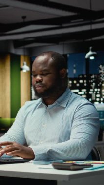 Dikey Afrikalı Amerikalı iş adamı görevlerini tamamlıyor ve masa lambasını kapatıyor. Kompleks proje için fazla mesai yaptıktan sonra gece geç saatlerde ofisten çıkıyor. İşi bitirdikten sonra saat kontrol ediliyor