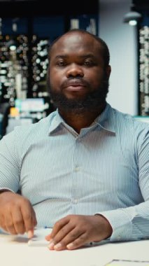 Yatırımcı grupla telekonferans görüşmesi yapan Dikey Video Siyah Erkek CEO ofis masasından yapılan uzak bir telefon görüşmesine katılıyor. Personel ağları, yönetim kuruluyla görüşmeler.