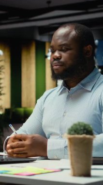 Dikey Video Siyah iş danışmanı mesai bitiminden sonra online bir video görüşmesine katılıyor, hissedarlarla internet üzerinden görüşmelerine katılıyor. Profesyonel adam ağ kurma oturumunda insanlarla iletişim kuruyor