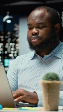 Dikey Video Black çalışanı e-postaları okuyor ve karanlık bir ofiste saatlerce çalışan çok uluslu bir şirket için internet görüşlerinden verileri belgeliyor. Atılgan 'ın hedefleri ve gelişimi. Kamera B.