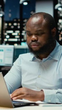 Dikey Siyah Adam, kağıt üzerinde temel fikirleri belgeliyor ve dizüstü bilgisayarda okuyor, geceleri görev planları yapıyor ve programlıyor. Hedefleri yansıtan bir sunum için el yazısıyla not alıyor