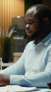 Dikey Video Afrikalı Amerikalı işçi e-postaları okuyor ve yönetim görevlerini yürütüyor. Çok uluslu bir şirketin görüşlerini belgeliyor. Akşamları iş amaçlarını araştırıyorum. Kamera B.