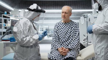 Tehlikeli madde giysisi içindeki doktorlar bir salgın sırasında hastaların hayati organlarını izliyorlar, laboratuvar verileri topluyorlar ve küresel bir felaket veya krizden kaçınmak için bulaşıcı salgın hastalıkları önlüyorlar. Kamera A.