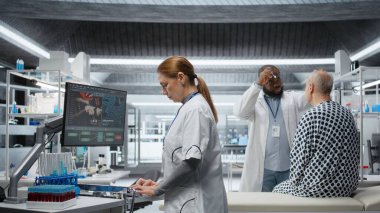 Klinik prosedürde hastanın hayati organlarına verilen kimyasal reaksiyonu inceleyen kadın uzman, yeni ilacı test ediyor ve tedavi sonuçlarını inceliyor. Sağlık hizmetleri ve toksikoloji yenilikleri araştırması. Kamera B.