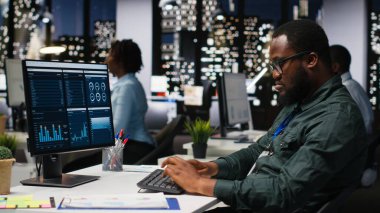 İş yönetimi için veri ve teknoloji kullanan erkek ofis çalışanı, raporlar oluşturmak ve verimliliği artırmak için monitördeki beyan grafiklerini gözden geçiriyor, hedeflere ulaşımı geliştiriyor. Görüş.