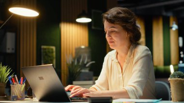 Memnun iş kadını, rahat rahat arkasını yaslayarak, kurumsal bir ortamda sakin bir dinlenme anının tadını çıkarıyor. Görevlerden sonra dinlenmek, güç verir. Kamera B.